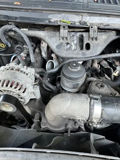 Diesel truck engine bay with the oil filter housing and alternator visible